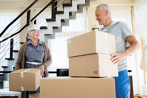 A senior couple unpacking moving boxes in their new home